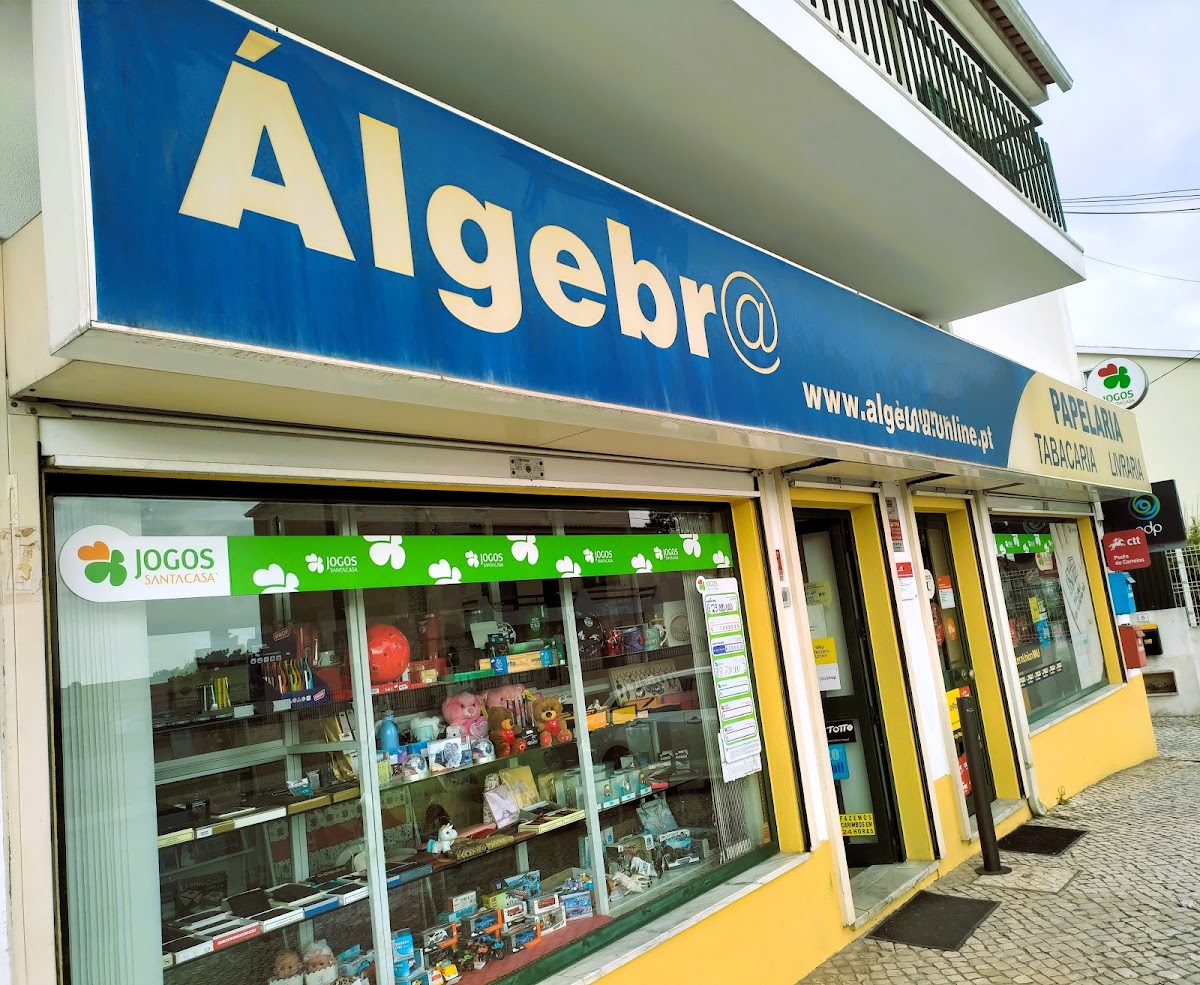 Fachada da Álgebra com o letreiro azul Álgebr@ — Papelaria, Tabacaria, Livraria